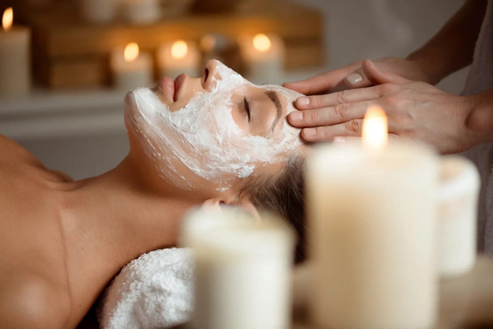 Entspannende Gesichtsbehandlung mit Maske bei Kerzenlicht